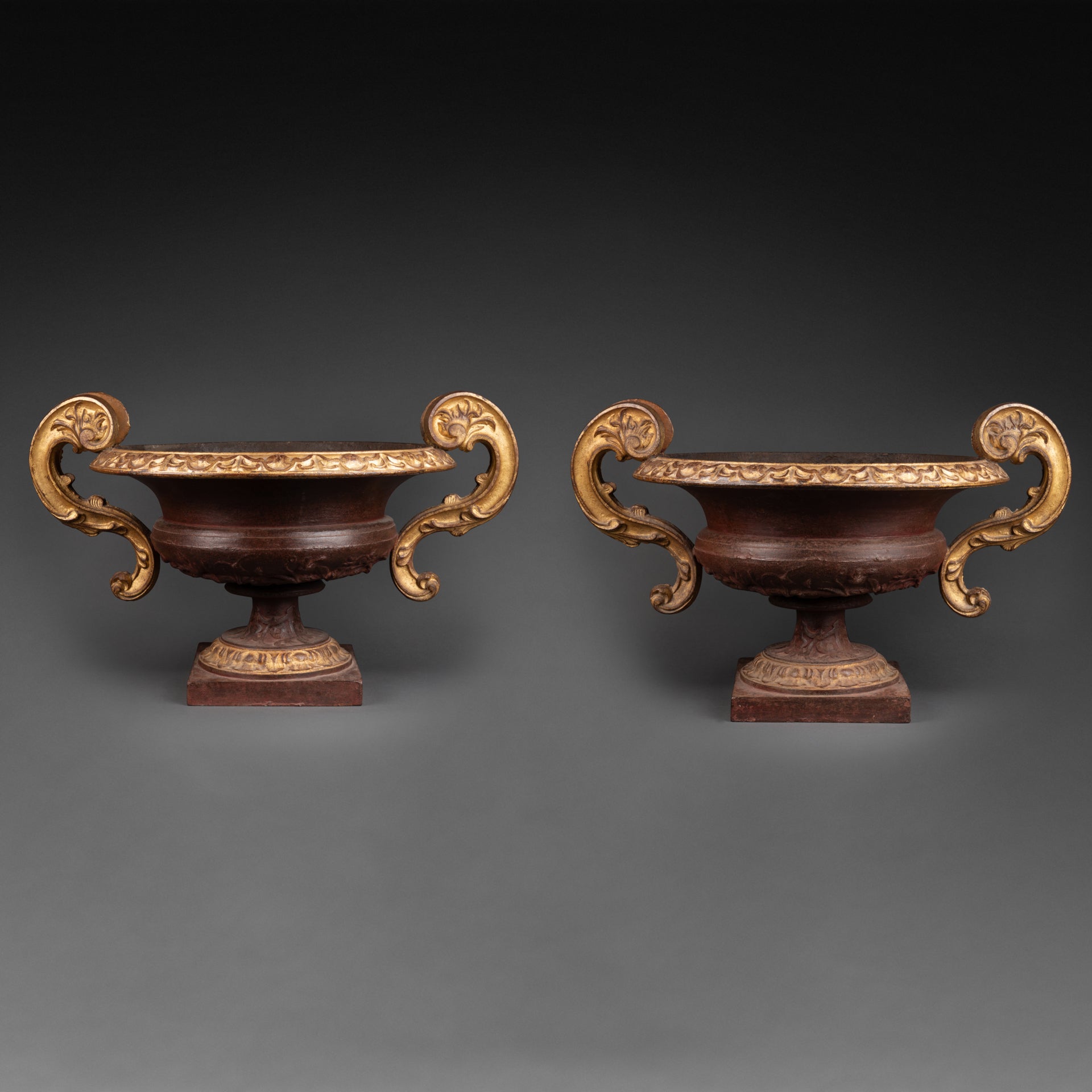 Large pair of patinated and gilded cast iron planters from the late 19th/early 20th century.